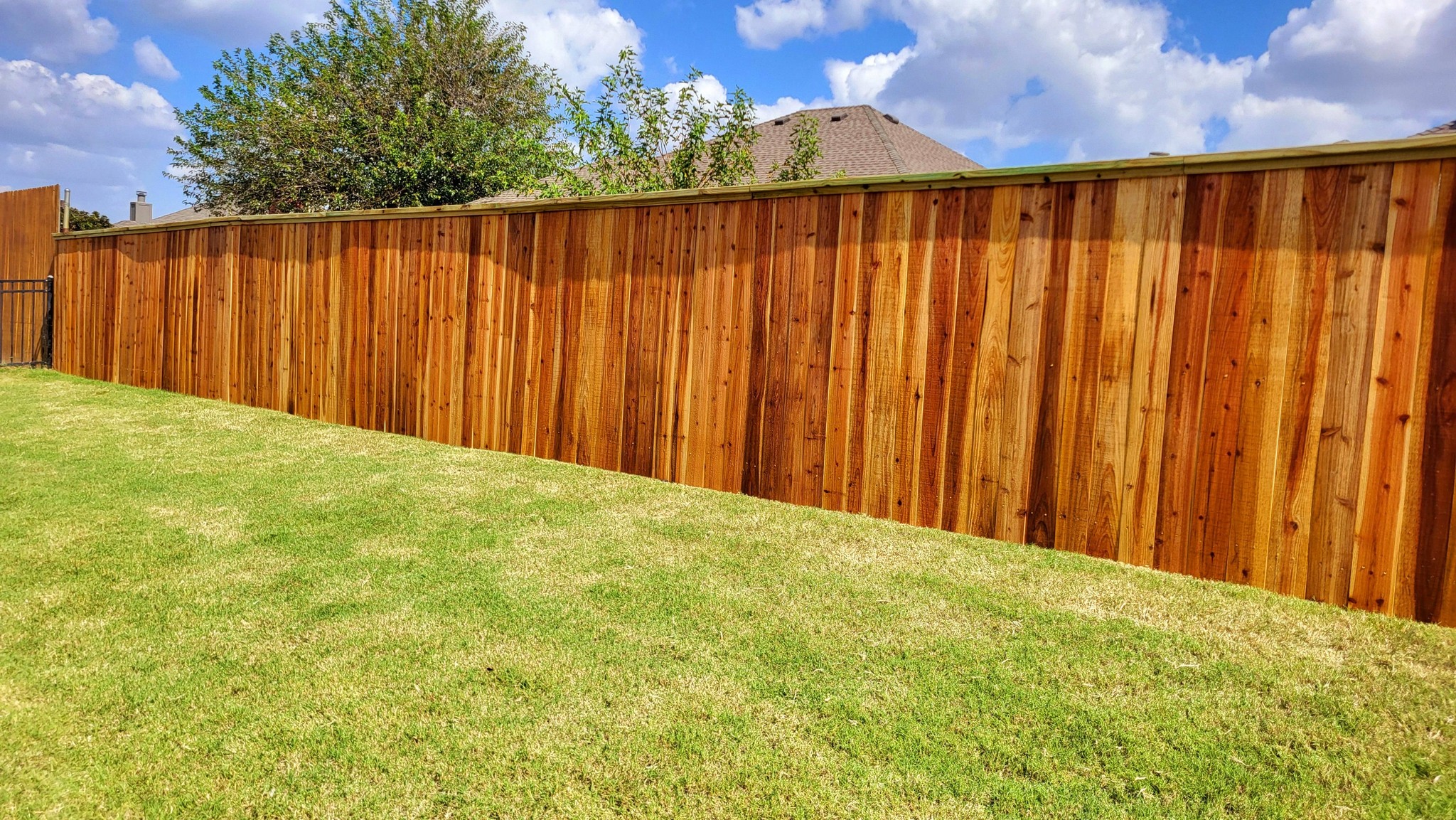 Stained cedar privacy fence along a backyard in Piedmont, Oklahoma by A&R Fencing and Landscaping